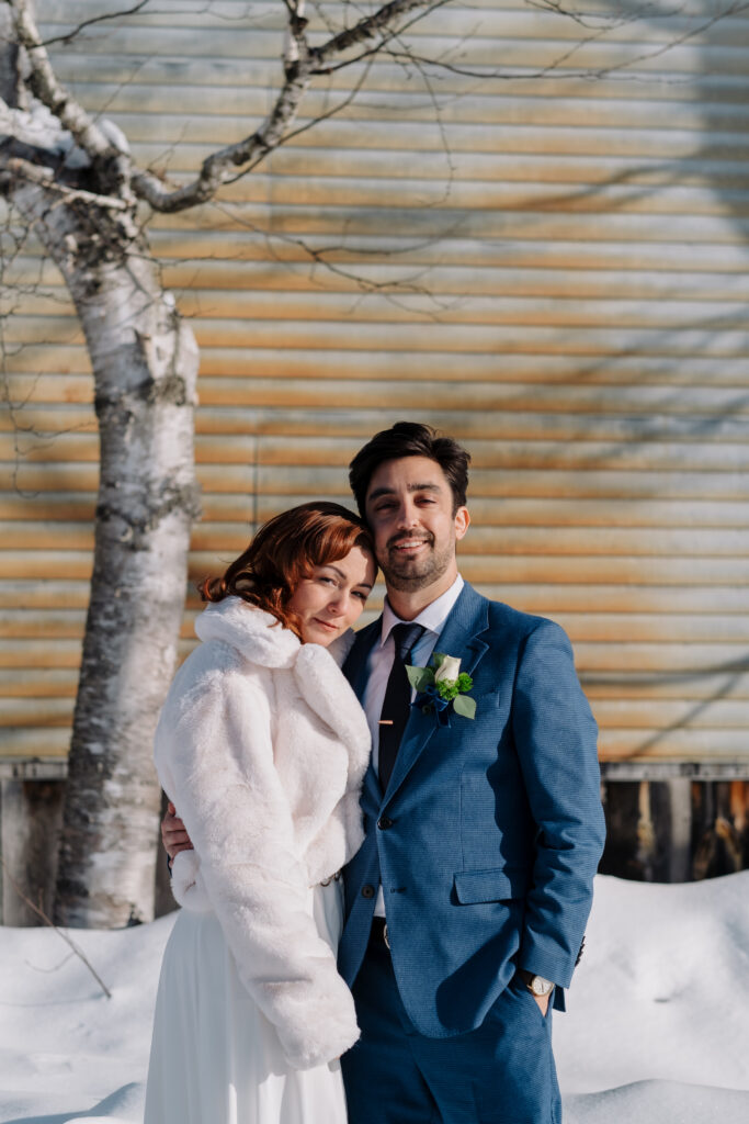Bride and groom in the snow during winter elopement in the White Mountains