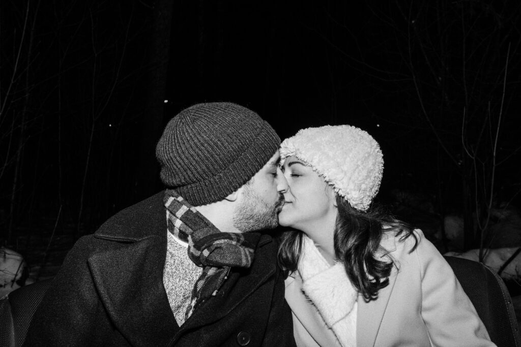 Couple kissing on winter sleigh ride in New Hampshire