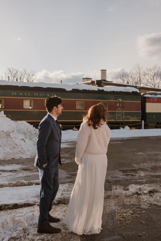 Documentary-style wedding photography of bride and groom in front of train