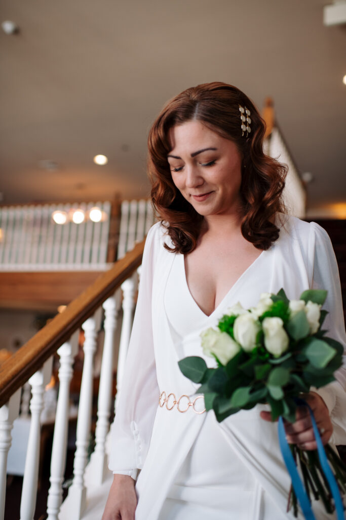 Bride walking down stairs for winter elopement in the white mountains